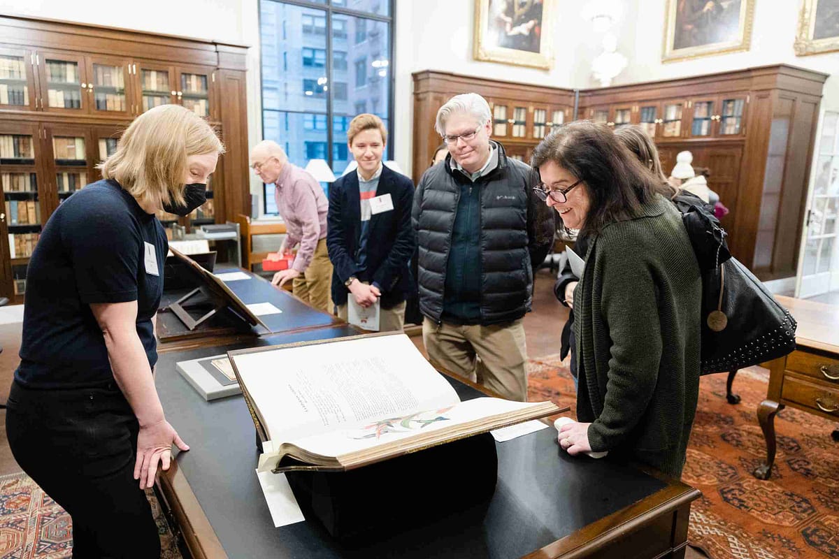 Event attendees view a rare book on display.