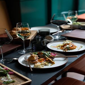 Food on plates with full glasses of wine.